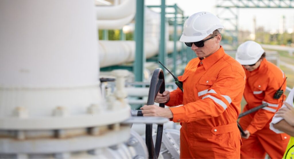 Oil and gas workers in high-visibility gear working on site
