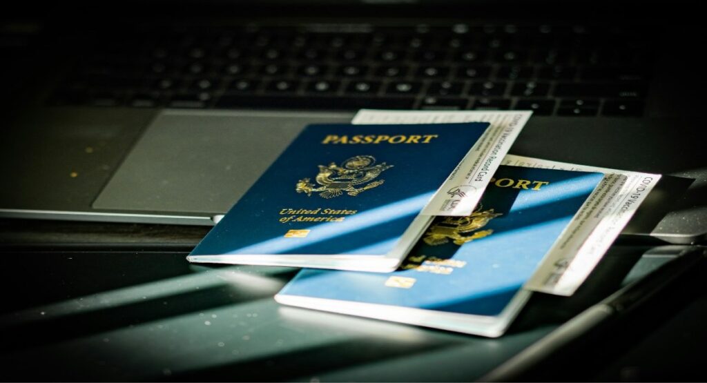 Two US passports with travel documents resting on a laptop keyboard