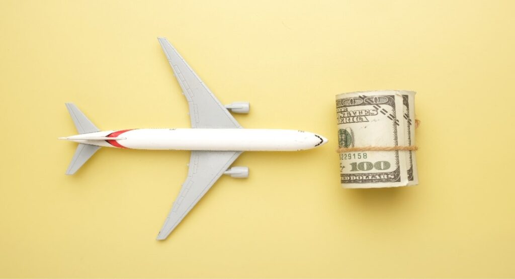 Toy airplane next to a roll of cash, representing cost optimisation strategies for FIFO and rotational workforce travel