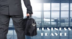 A business traveler in a suit carrying a briefcase inside an airport terminal with a plane visible through the window