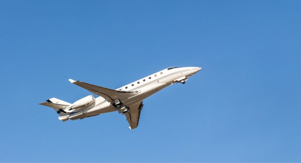 Private jet in flight against a clear blue sky