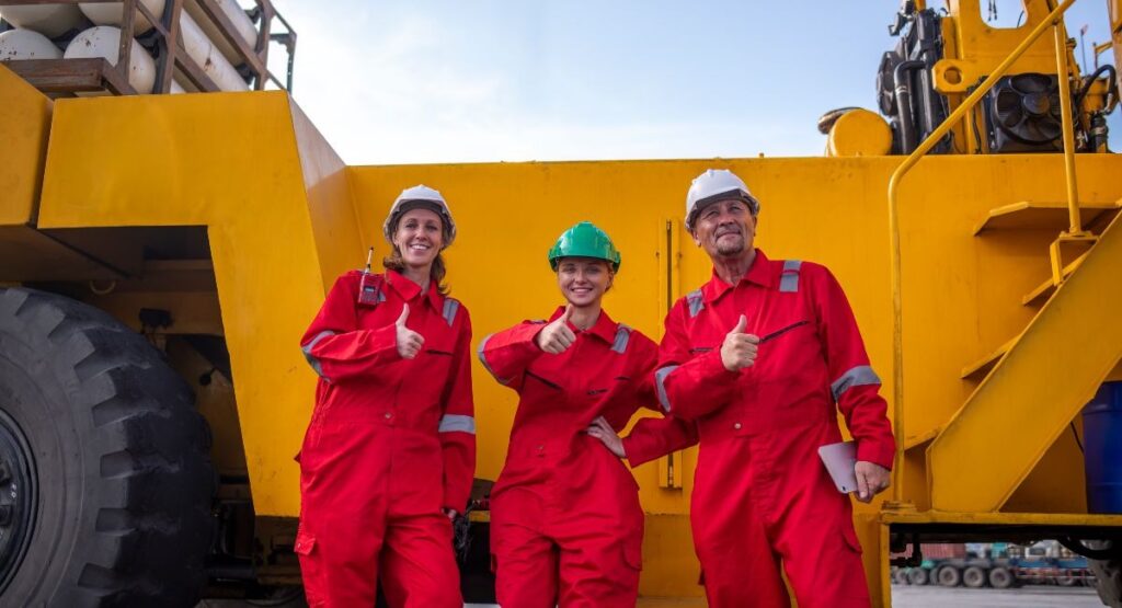 Workers in Red Overalls Giving Thumbs Up at Site
