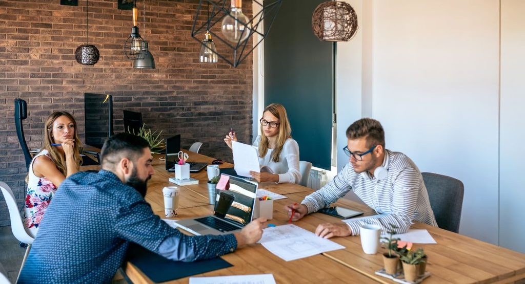 Four people discussing business travel management needs in a meeting